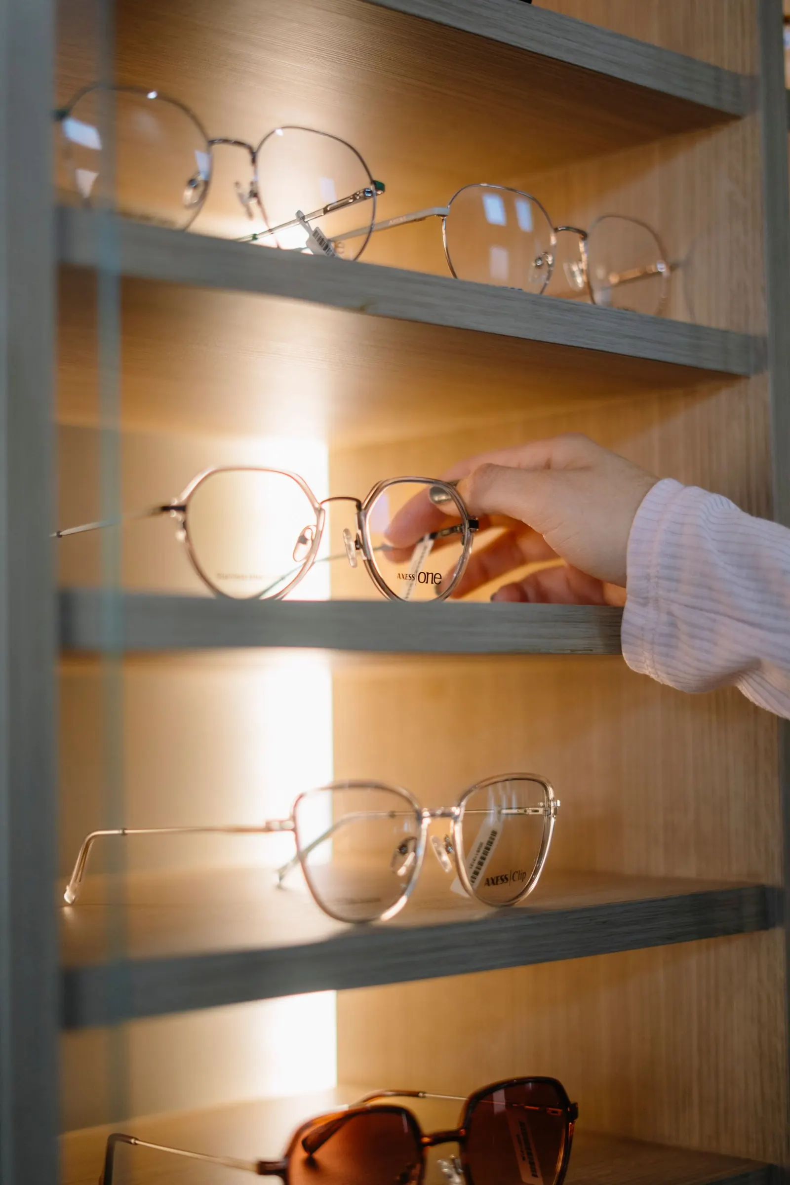 Selection of Ray-Ban, Persol and Oakley frames on a wooden display